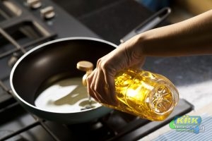 Someone pours cooking oil into a pan