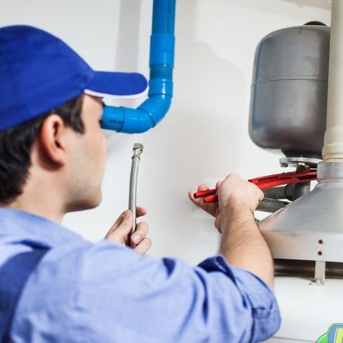 A Picture of a Plumber Repairing a Water Heater.